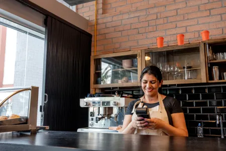 Shop owner managing her Ingenico Payment Terminal with Payment Terminal Management Systems