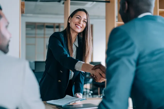 Woman shaking hands with man over a desk